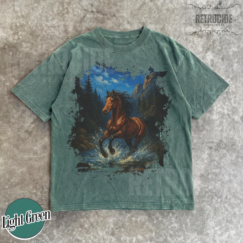 May include: Light green t-shirt with a brown horse graphic running through water, with mountains and trees in the background. The shirt has the text "RETROCIDE" and "Light Green" on it.