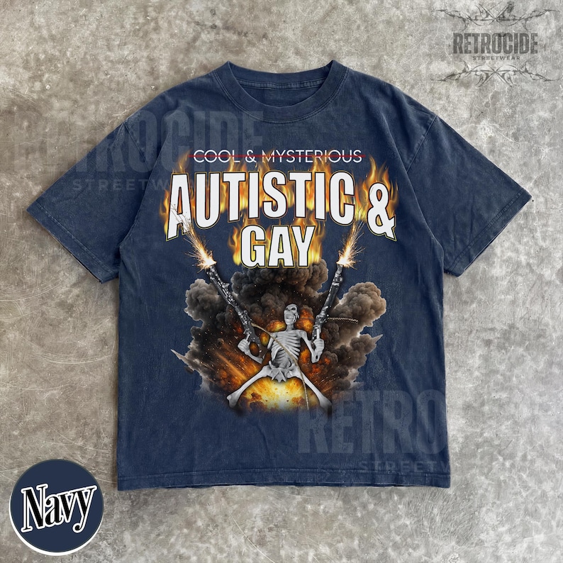 May include: Navy blue t-shirt with the text "COOL & MYSTERIOUS AUTISTIC & GAY". The graphic features a skeleton holding two guns with a fiery explosion in the background. The shirt has a vintage, distressed look.