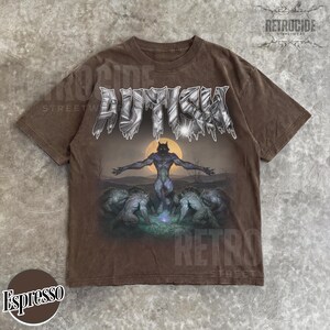 May include: A brown short-sleeve t-shirt featuring the word AUTISM in a metallic, jagged font at the top. Below the text is a graphic of a central werewolf figure standing with arms outstretched before a full moon, surrounded by four other wolves.