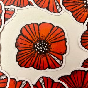 May include: A set of red poppy flower stickers with black outlines and white centers. The stickers are arranged in a circular pattern on a white background.