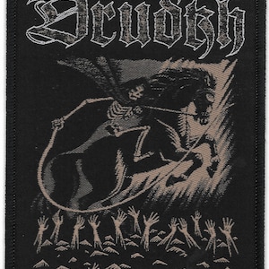 May include: Black and white embroidered patch with the word "Drudkh" in a gothic font at the top. A skeletal figure riding a horse is depicted in the center of the patch. The horse is rearing up and the rider is holding a sword. The background is a dark gray color. At the bottom of the patch, there are many outstretched hands reaching up.