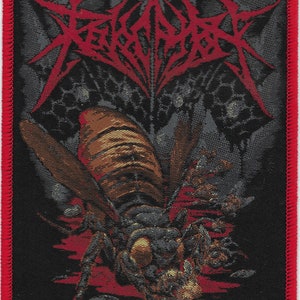 May include: Black and red embroidered patch with the band name "REVOLVER" in a stylized font. The patch features a detailed image of a large, menacing insect with a red, black, and brown color scheme.