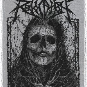 May include: A black and white patch featuring a skull-faced figure with long hair, framed by a dark, ornate border. The word "FERALITOR" is written in a spiky font above the figure's head. The patch has a woven texture and a white border.