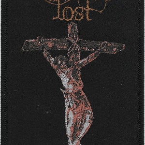May include: Black woven patch with the band name "Paradise Lost" in brown lettering and a stylized image of a person on a cross. The text "Gothic" is printed in brown at the bottom of the patch.