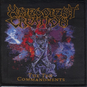 May include: A square black fabric patch featuring the yellow text Malevolent Creation at the top and The Ten Commandments at the bottom. The center displays a dark, abstract, horned figure surrounded by a vibrant purple, blue, and red nebula design.