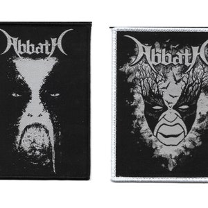 May include: Two black and white patches featuring the band Abbath. One patch displays a face with a long beard, the other shows a mask with a tree and bat design. Both patches have the band's name in a stylized font.