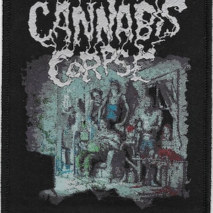 May include: Black rectangular patch with the words "CANNABIS CORPSE" in white, stylized lettering. Below the text is a detailed, multi-colored illustration of a group of figures. The text "FROM WISDOM TO BAKED" is at the bottom.