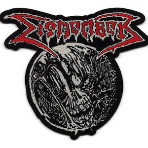 May include: A black patch with the word "Dismember" in red, stylized text across the top. Below the text is a circular graphic of a skull-like face in black and white. The patch has a black border.
