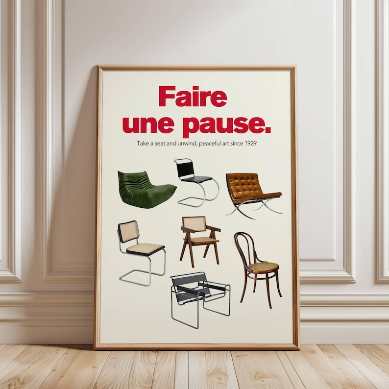 Framed “Faire une Pause” poster featuring iconic mid-century chairs, leaning against a white wall in a classic interior.