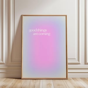 May include: A framed poster with a gradient background of purple, pink, and blue. The text "good things are coming" is printed in white on the poster.