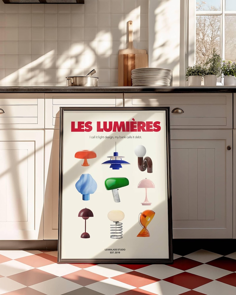 May include: A framed poster featuring a collection of colorful, stylized lamps. The poster's title, "LES LUMI&Egrave;RES," is in red, with the text "I call it light design, my bank calls it debt." The bottom of the poster reads "LEVKALADE STUDIO EST. 2019."