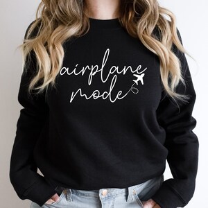 a woman wearing a black sweatshirt that says air force mode