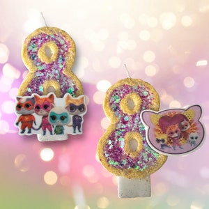 May include: Two pink and gold glitter birthday candles shaped like the number eight. One candle has a sticker of the characters from the show "PAW Patrol" on it. The other candle has a sticker of the characters from the show "The Octonauts".