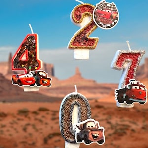 Può includere: Set di quattro candele di compleanno a tema Cars. Le candele sono rosse, argentate e dorate con glitter. Ogni candela presenta un personaggio diverso di Cars. I numeri 2, 4, 7 e 0 sono sulle candele.