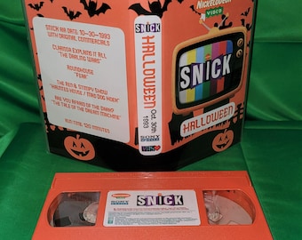 Könnte beinhalten: Ein VHS-Band des Nickelodeon SNICK Halloween-Specials vom 30. Oktober 1993. Das Band enthält Episoden von Clarissa Explains It All, Roundhouse, Ren & Stimpy und Are You Afraid of the Dark? Das Band ist orange mit schwarzem Text und einem schwarz-orangenen Fernsehbildschirm mit dem SNICK-Logo.