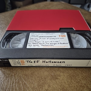 Pode incluir: Uma fita VHS Fuji T-60 preta com tampa vermelha. O rótulo diz "TGIF Halloween" de 1997. A fita inclui os programas "Sabrina", "Teen Angel", "Boy Meets World" e "You Wish".