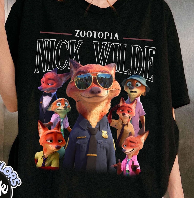 Puede incluir: Camiseta negra con el texto blanco "ZOOTOPIA NICK WILDE" sobre un gr&aacute;fico de Nick Wilde y otros personajes de zorro. Los zorros llevan gafas de sol, uniformes y ropa informal de la pel&iacute;cula animada.