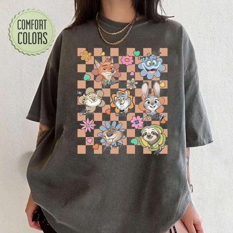 Puede incluir: Camiseta gris oscuro con personajes de dibujos animados de Zootopia sobre un fondo a cuadros con flores y corazones. La camiseta tiene el texto "Comfort Colors" en un dise&ntilde;o circular.