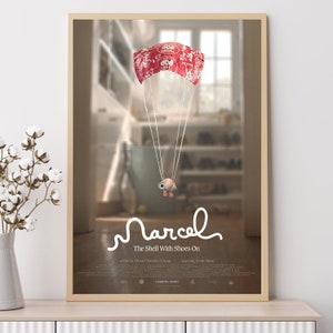 Pode incluir: Um cartaz de filme para o filme "Marcel the Shell With Shoes On". O cartaz apresenta um pequeno personagem de concha animado que usa sapatos vermelhos e um paraquedas feito de um recipiente de plástico vermelho e branco. O personagem está voando por um quarto com uma janela no fundo. O texto "Marcel The Shell With Shoes On" está escrito em branco, em itálico.