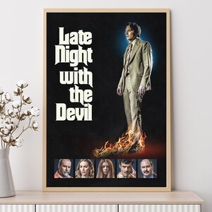 May include: A movie poster with the title "Late Night with the Devil" in a retro font. A man in a brown suit stands on fire with a blue background. Below the title are five smaller images of the actors in the movie.