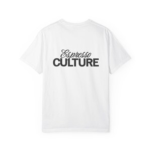 May include: White t-shirt featuring the text "Espresso CULTURE" in black. The word "Espresso" is in a cursive font, and "CULTURE" is in a bold, sans-serif font. The shirt is a simple, casual style.
