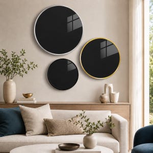 a modern living room with a white sofa, a round mirror with a gold frame, and a round black mirror with a gold frame. The room is decorated with various plants, vases, and books, creating a stylish and comfortable atmosphere.