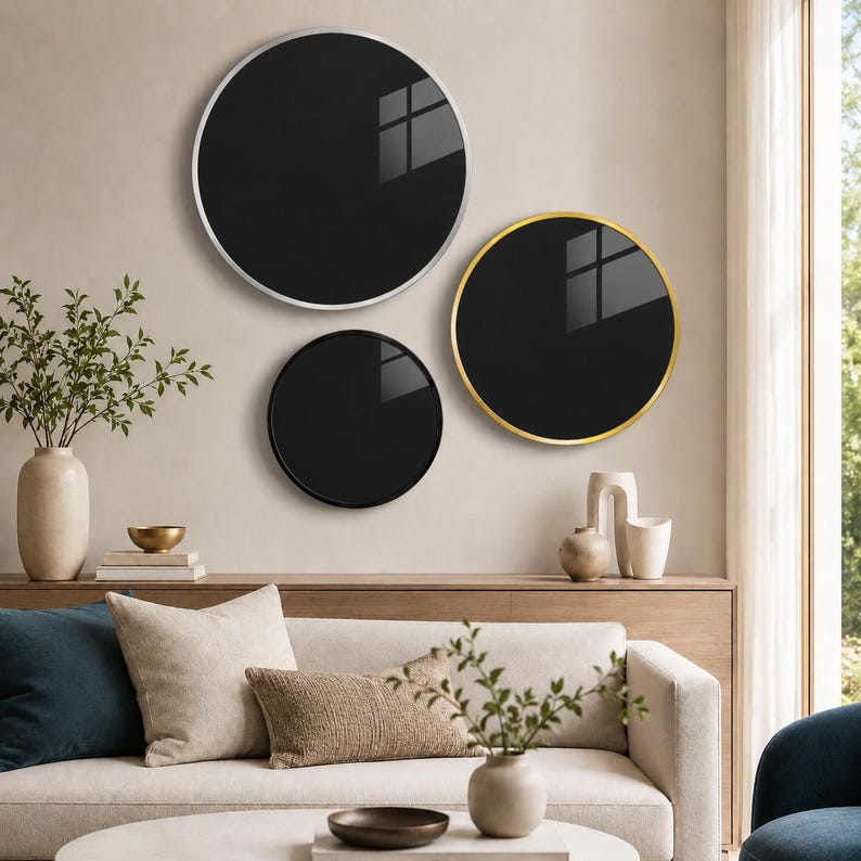 a modern living room with a white sofa, a round mirror with a gold frame, and a round black mirror with a gold frame. The room is decorated with various plants, vases, and books, creating a stylish and comfortable atmosphere.
