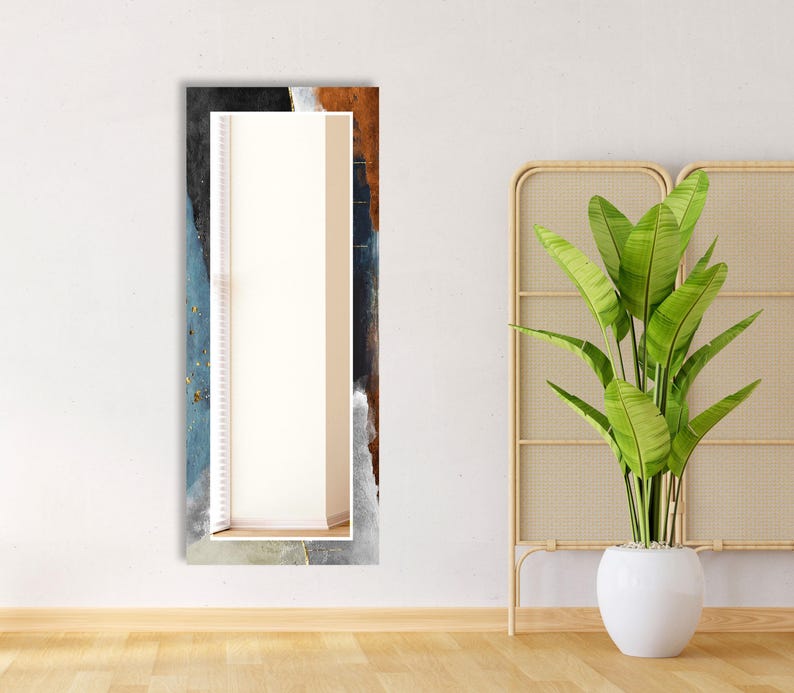 a plant in a white vase next to a mirror