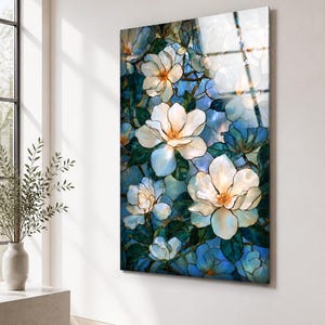 Ready-to-hang vertical glass artwork with white magnolia flowers and a cool blue garden background.