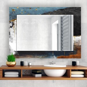 a bathroom with a sink and a mirror
Rectangular tempered glass wall mirror with a dark and gold abstract design frame, adding a sophisticated touch to wall mirror decor.
