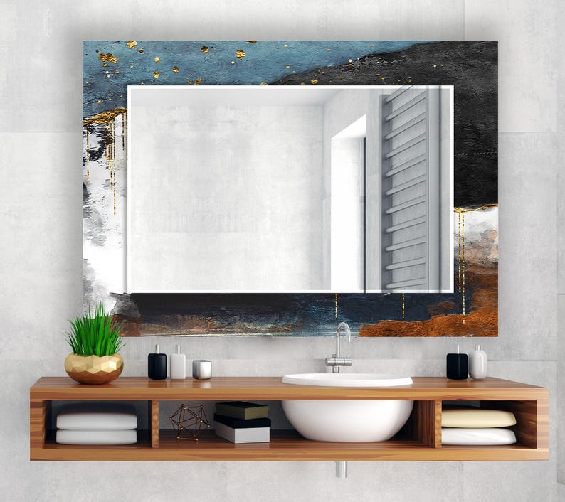 a bathroom with a sink and a mirror
Rectangular tempered glass wall mirror with a dark and gold abstract design frame, adding a sophisticated touch to wall mirror decor.
