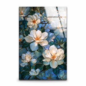 White magnolia glass artwork with dark teal leaves and warm orange flower centers.