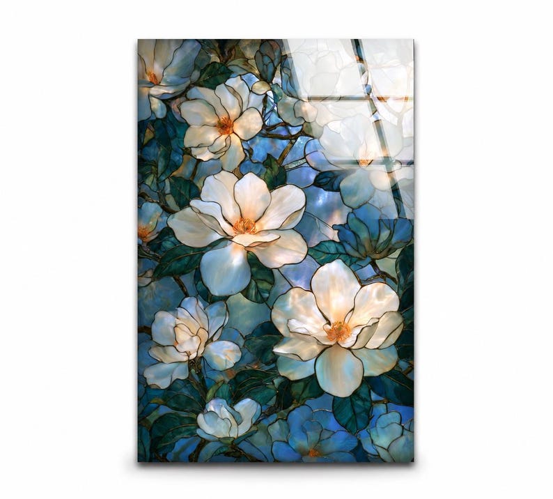White magnolia glass artwork with dark teal leaves and warm orange flower centers.