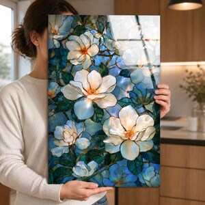 Framed or unframed magnolia glass wall art with ivory flowers and dark teal foliage.