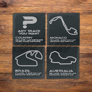 Könnte beinhalten: Vier quadratische Schieferuntersetzer mit weißen Umrissen von Rennstrecken. Ein Untersetzer hat ein Fragezeichen und den Text "ANY TRACK YOU WANT". Die anderen zeigen die Strecken von Monaco, Brasilien und Australien.