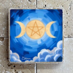 Pode incluir: Base quadrada com um design celestial. Apresenta um pentagrama central, luas crescentes e um sol sobre um céu azul rodopiante com nuvens brancas. A assinatura do artista, "Cathelineau", é visível.