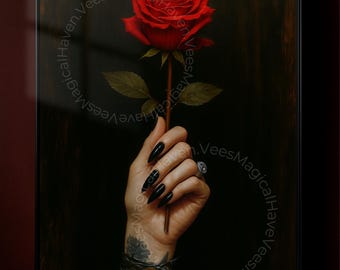 May include: A framed print showing a red rose held by a hand with long, black nails. The hand wears a silver ring and has a tattoo. The dark background features the text "VeesMagicalHaven" circling the image.
