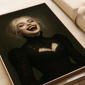 May include: A framed portrait of a woman with pale skin and blonde hair, laughing with fangs visible. She wears a black lace dress with a high collar and a cutout at the chest. The artwork has a dark, gothic aesthetic.