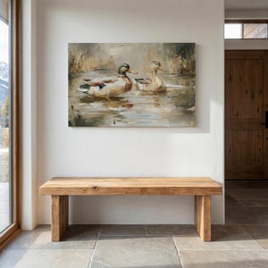 a wooden bench situated in a room with a large painting of ducks on the wall above it.