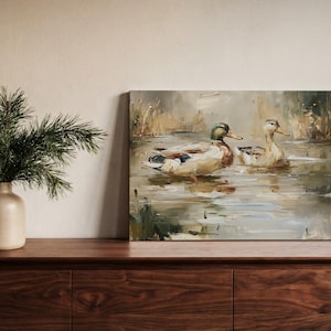 a painting of ducks swimming in a pond, displayed on a wooden shelf next to a vase with greenery.