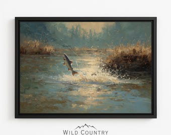 May include: A framed wall art print featuring an oil painting of a fish leaping out of a river. The scene depicts water splashes, golden sunlight reflecting on the surface, and tall grasses along the riverbank. The text WILD COUNTRY COLLECTIVE appears below.