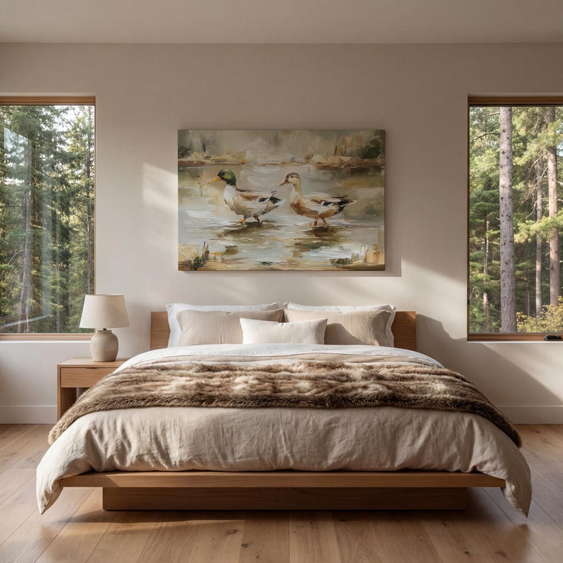 a serene bedroom with a large bed, a painting of ducks on the wall, and two windows overlooking a forest.