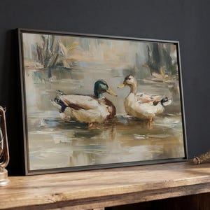 a painting of two ducks in a pond, displayed on a wooden table.