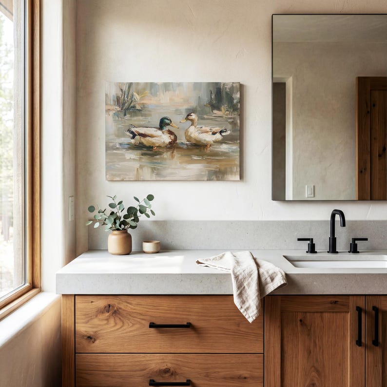 a bathroom with a large mirror, a wooden vanity, and a painting of ducks on the wall.