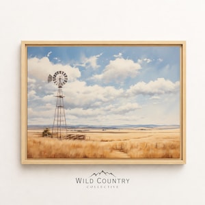 Puede incluir: Pintura de paisaje enmarcada que representa una escena rural con un molino de viento, hierba alta y un cielo azul nublado. La obra de arte está en un marco de madera y presenta el texto "WILD COUNTRY COLLECTIVE" en la parte inferior.