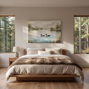a serene bedroom scene with a large bed, a painting of ducks swimming in a lake, and two windows overlooking a forest.