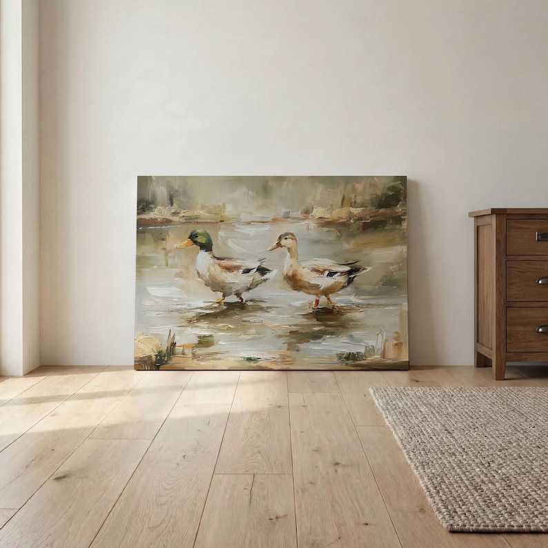 a large painting of two ducks standing in a body of water, with a wooden floor and a wooden dresser visible in the background.