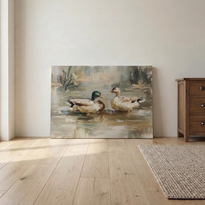 a painting of two ducks swimming in a pond, displayed on a wall in a room with a wooden floor.