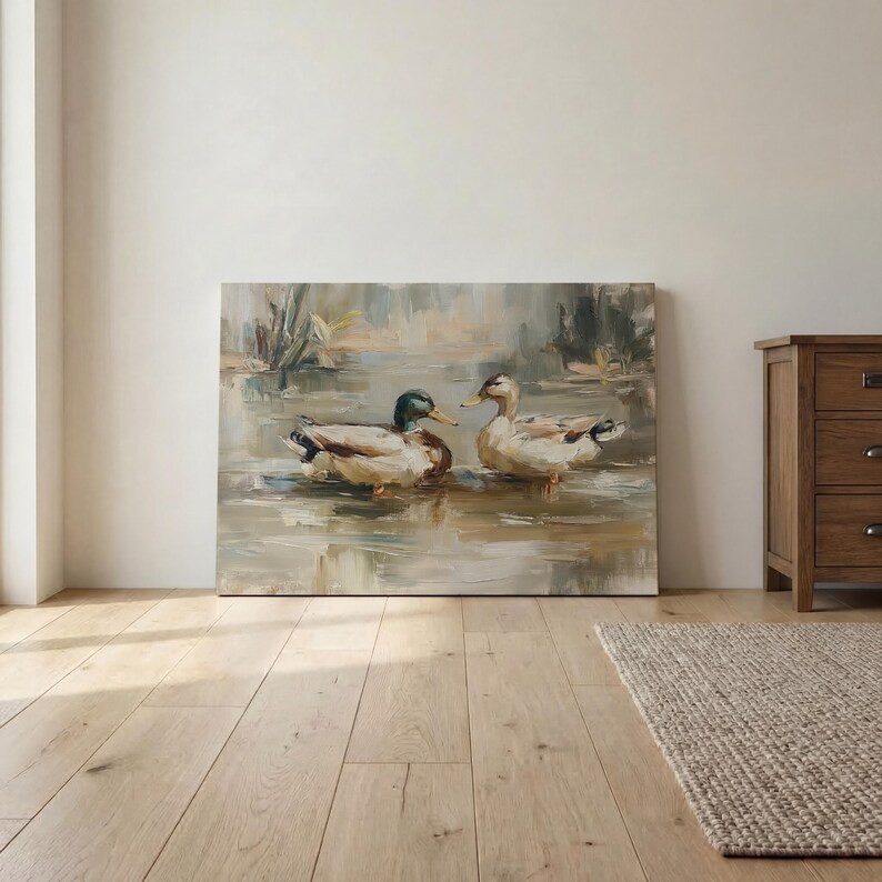 a painting of two ducks swimming in a pond, displayed on a wall in a room with a wooden floor.