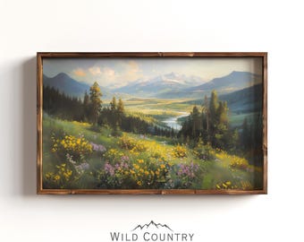 May include: A rectangular landscape painting in a dark brown wooden frame depicting a mountain valley with a winding river, evergreen trees, and a foreground filled with yellow and purple wildflowers under a soft, light-filled sky.